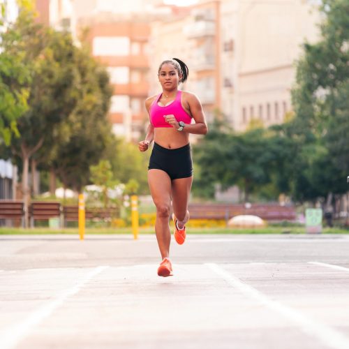 latin sportswoman running on the city
